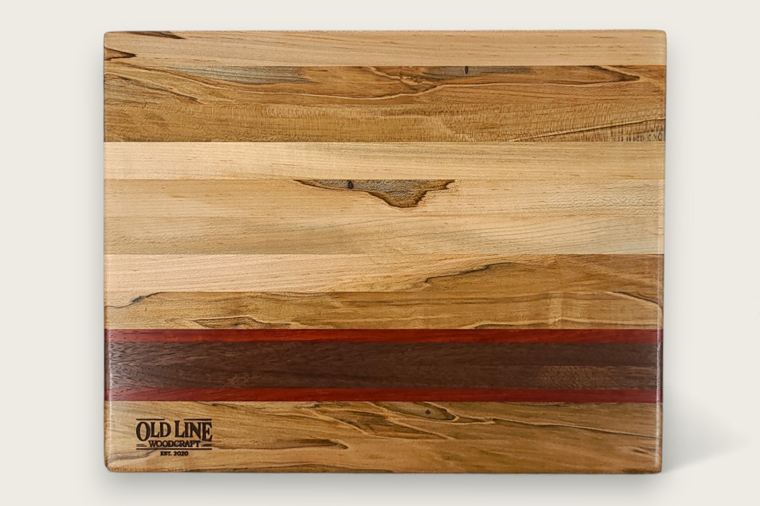 Spaulted Maple Butcher Block Board (#140) with light maple edge grain, walnut and purpleheart accents, and a recessed handle.