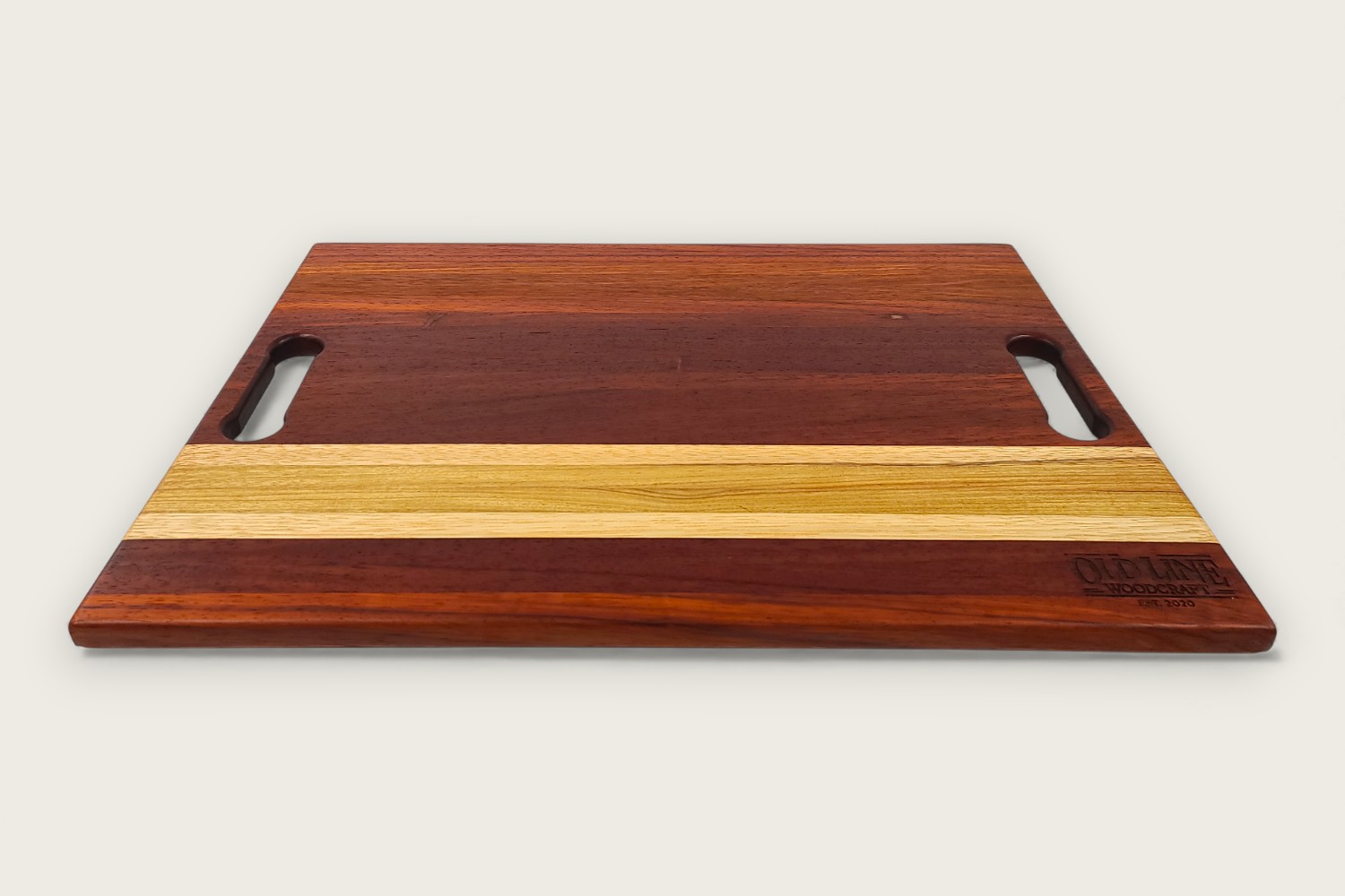 Padauk Pro Series cutting board with bold reddish tones, edge-grain pattern, rectangular shape, and tung oil finish.