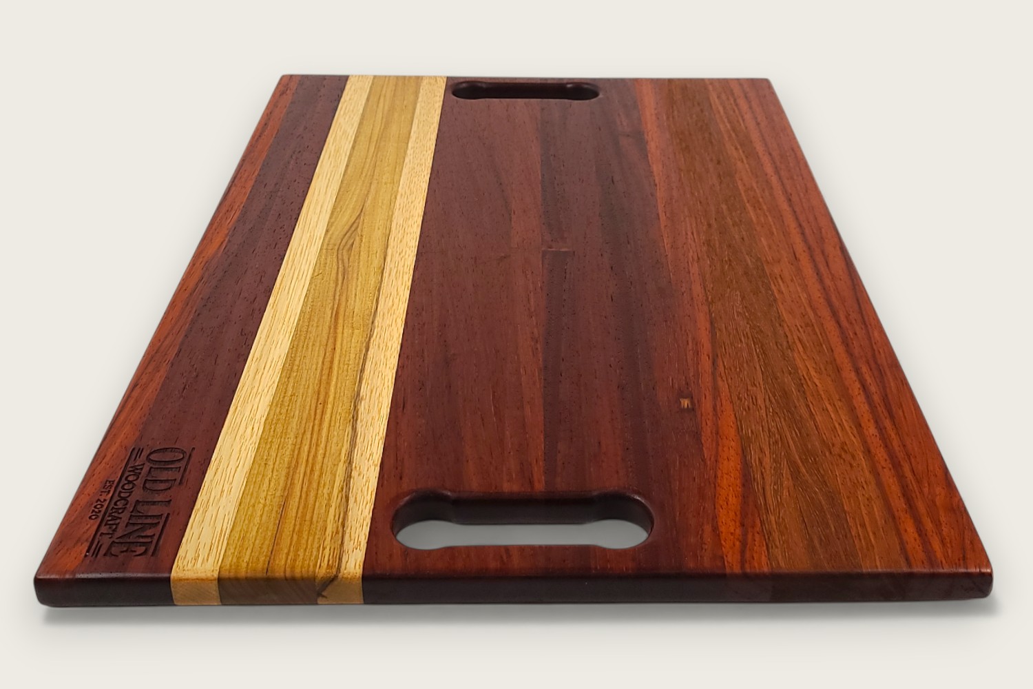 Padauk Pro Series cutting board with bold reddish tones, edge-grain pattern, rectangular shape, and tung oil finish.