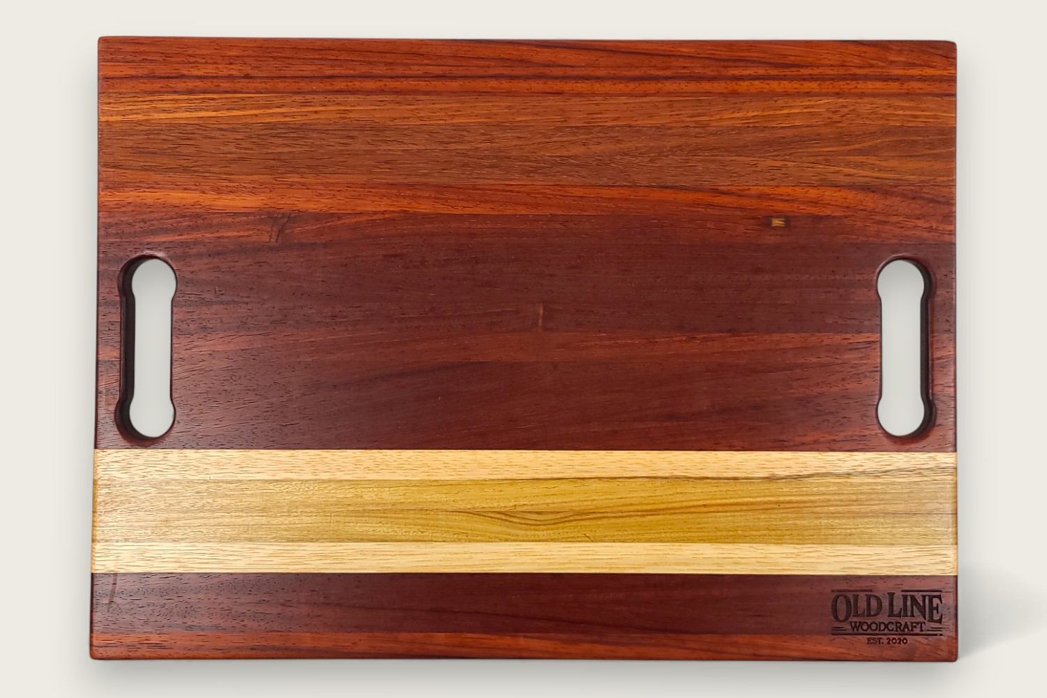 Padauk Pro Series cutting board with bold reddish tones, edge-grain pattern, rectangular shape, and tung oil finish.