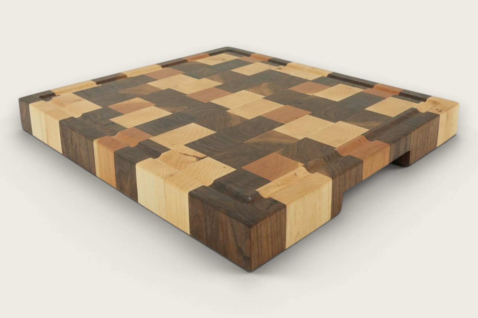 Walnut end-grain Calico chopping board with checker pattern, recessed handles, and rich brown tones.