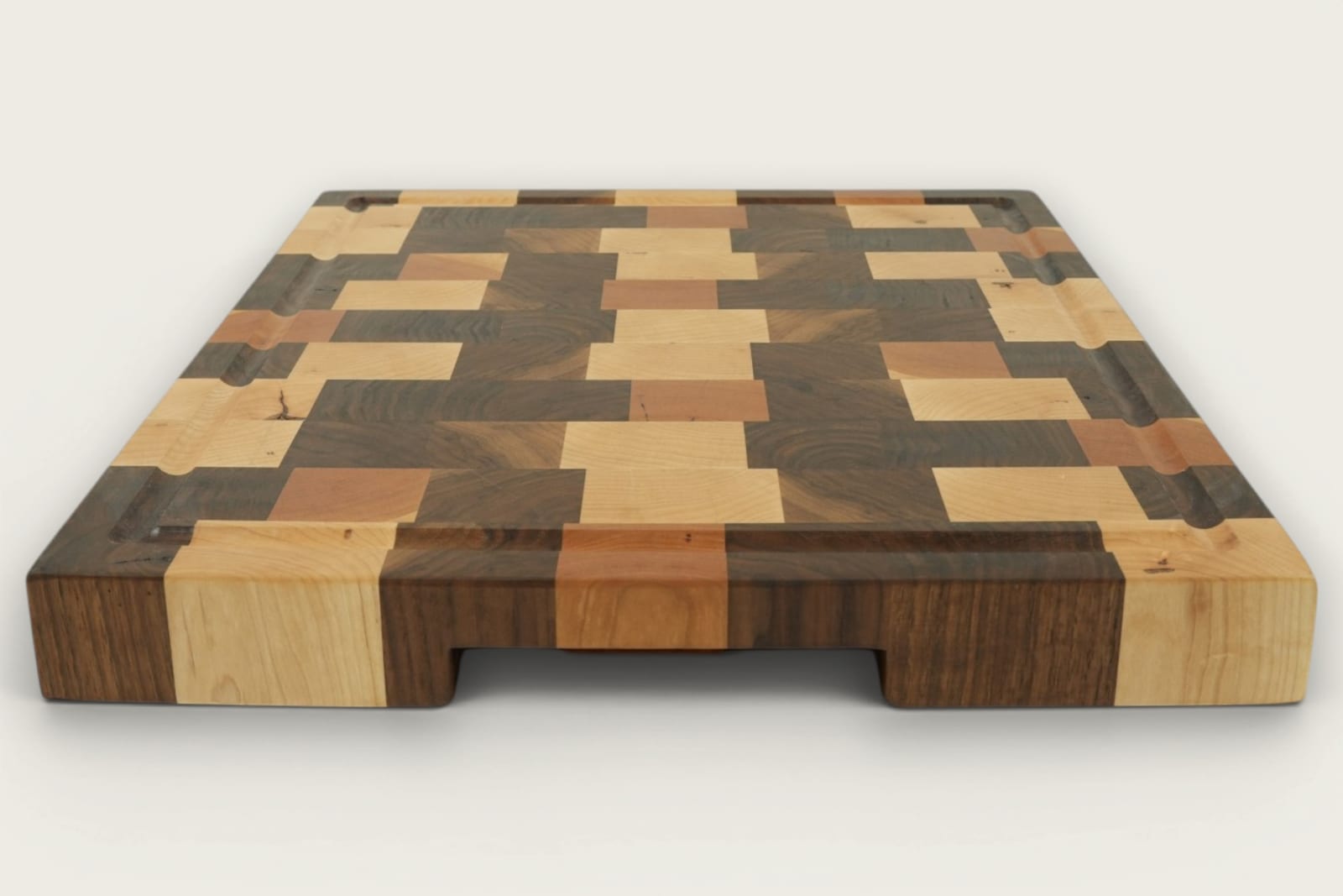 Walnut end-grain Calico chopping board with checker pattern, recessed handles, and rich brown tones.