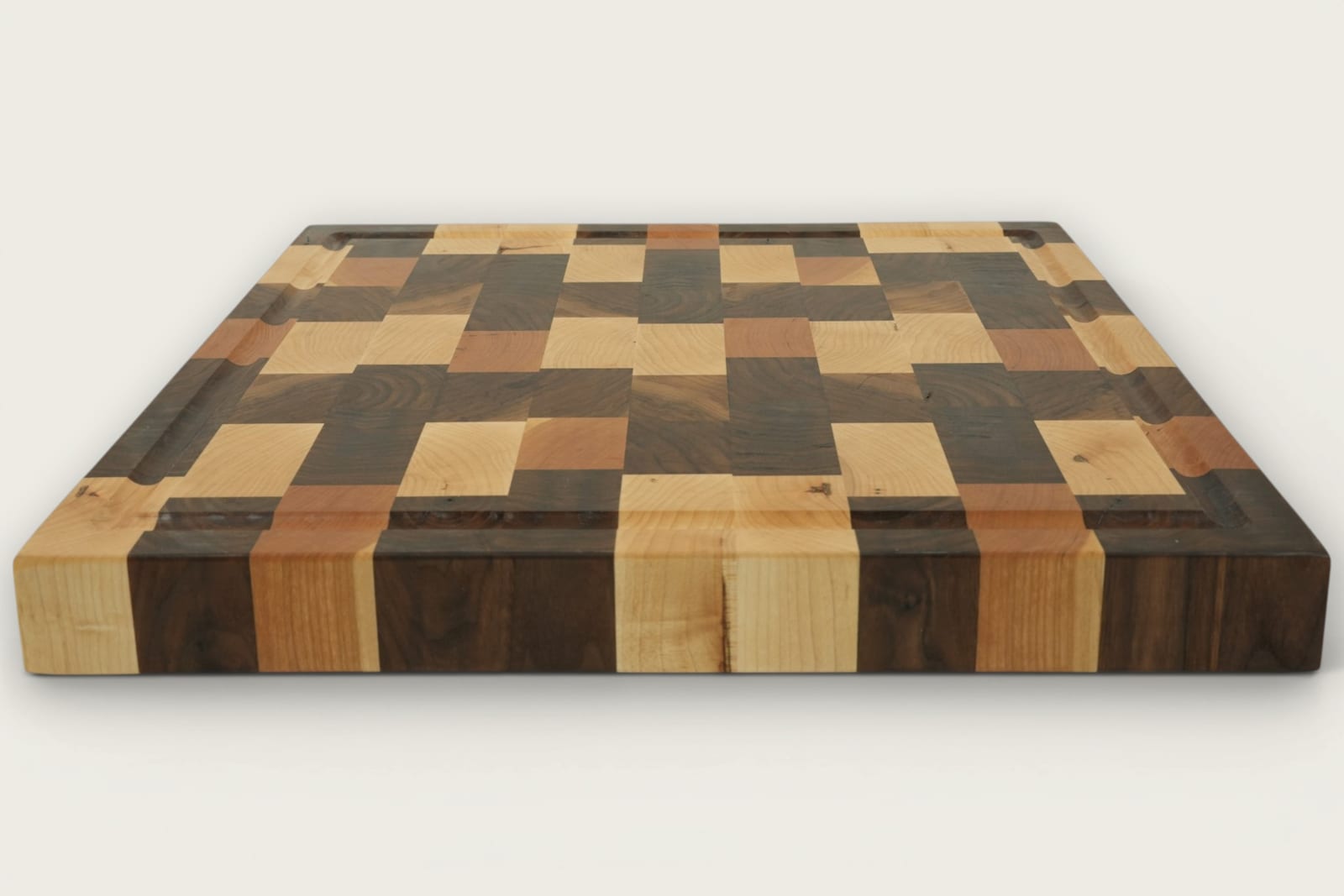 Walnut end-grain Calico chopping board with checker pattern, recessed handles, and rich brown tones.