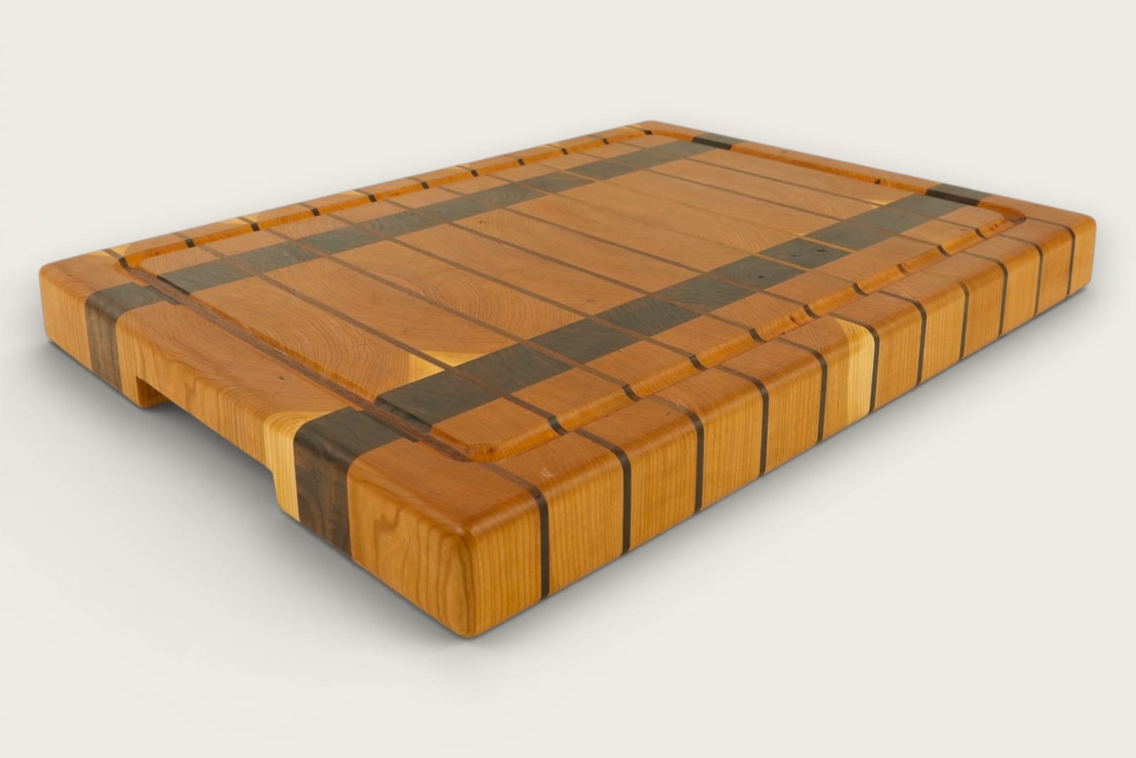Cherry and walnut chopping block with vertical end-grain pattern, warm amber tones, and recessed handles.