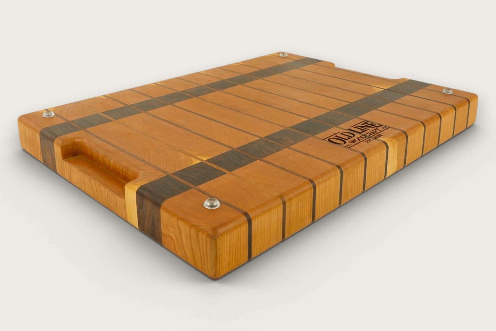 Cherry and walnut chopping block with vertical end-grain pattern, warm amber tones, and recessed handles.