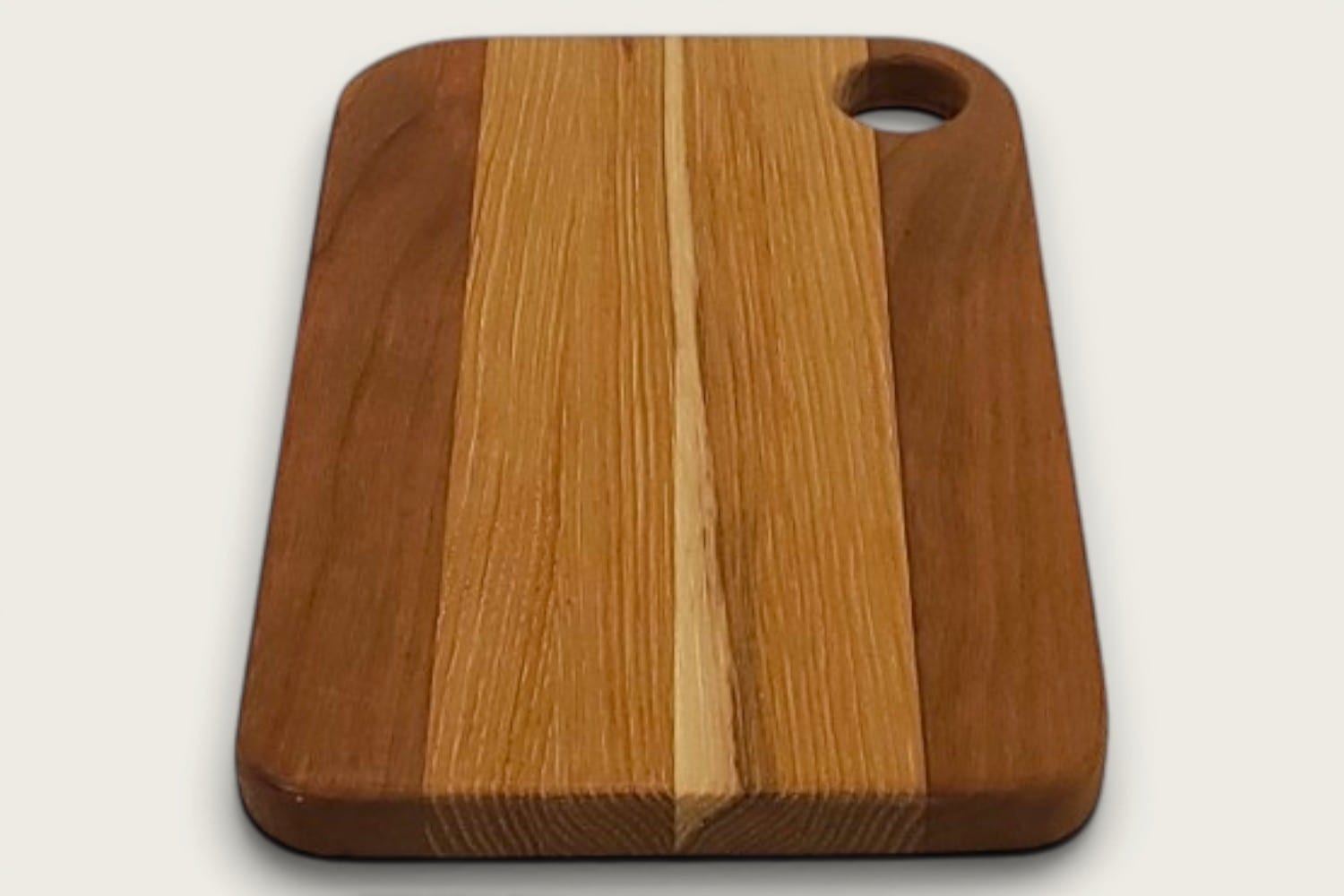 Hickory and Cherry Prep Board, rectangular edge-grain cutting board with tung-oil finish and cutout handle.