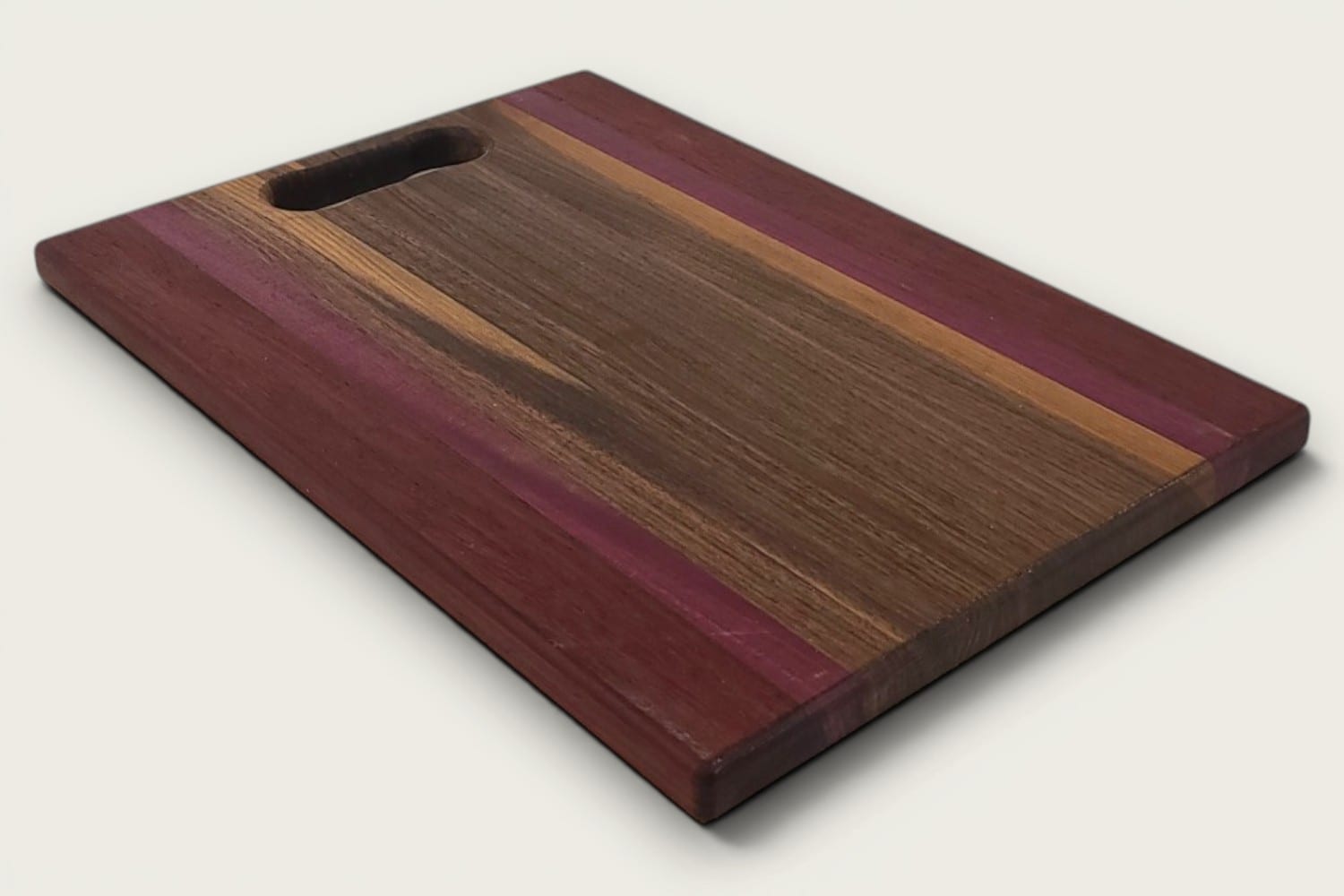 Walnut Padauk Purpleheart Pro Series Board, edge-grain rectangular cutting board with tung-oil finish, bone handle, warm brown and purple tones.