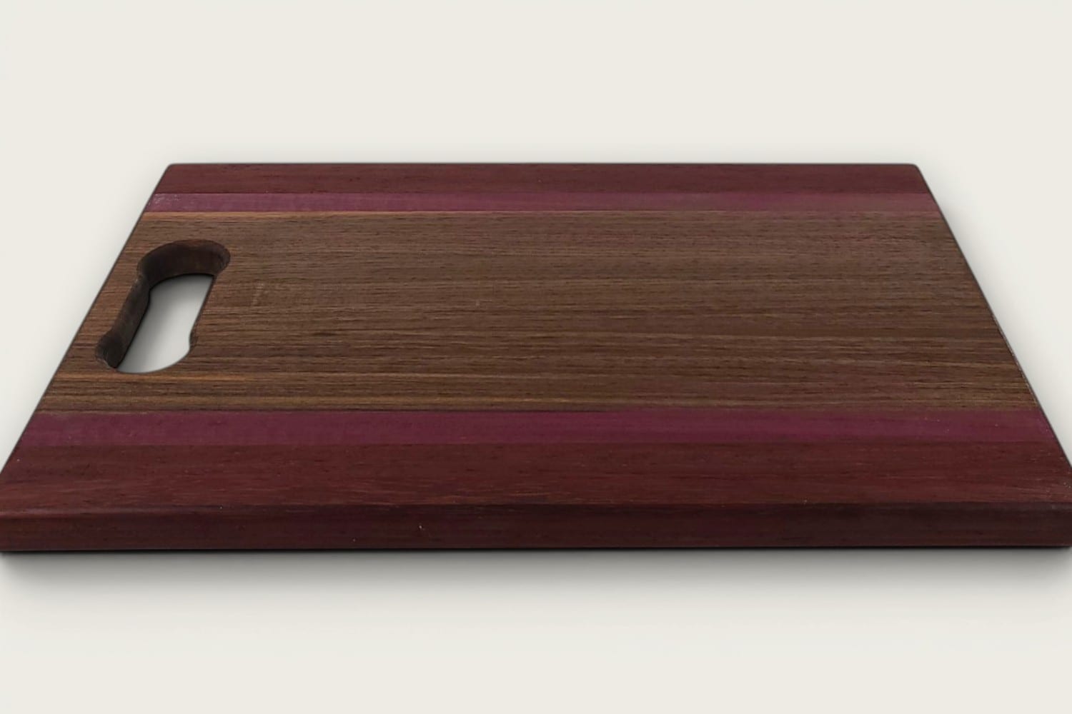 Walnut Padauk Purpleheart Pro Series Board, edge-grain rectangle with tung oil, bone handle, warm brown and purple tones.