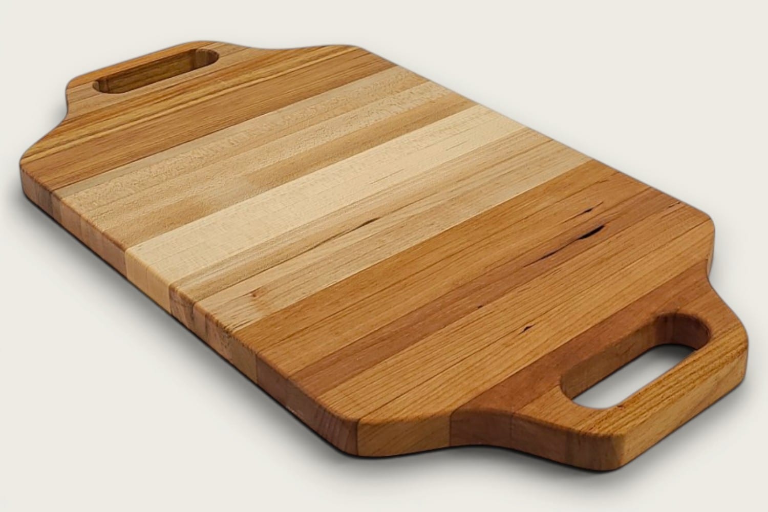 Maple Heritage Charcuterie Board, edge-grain with tung oil, heritage shape, cutout handle, warm tan tones.