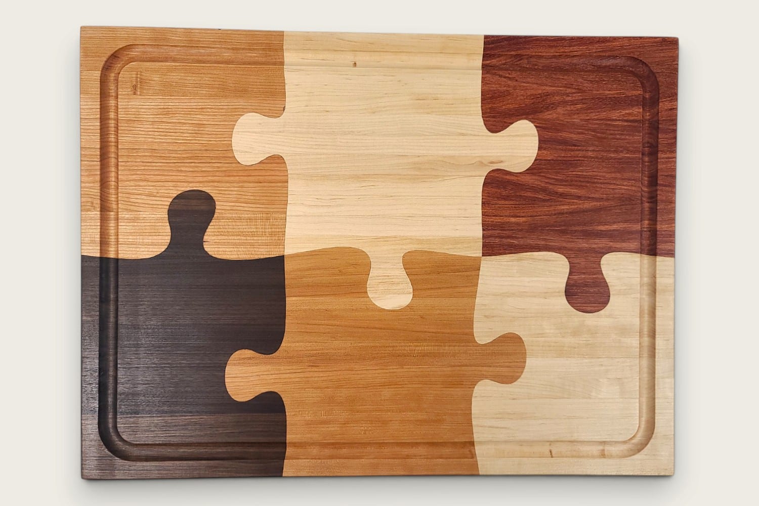 The Pitmaster Butcher Block Puzzle Board, cherry edge grain, tung-oiled rectangle with checker puzzle inlay.